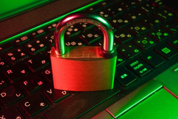 Red padlock on black computer keyboard representing cybersecurity and AI ethics