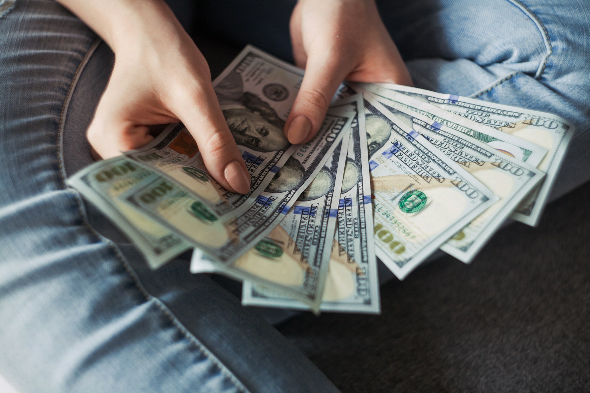 Fan of dollar banknotes representing millennial wealth building