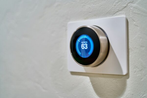 Gray smart thermostat displaying temperature for smart connected living